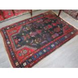 An early 20th Century Eastern wool rug worked in natural red,