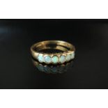 A 9ct gold ring set with six opals in rubover setting, size Q, 2.