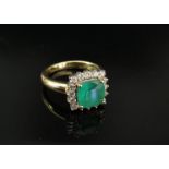 A gold emerald and diamond ring, the square emerald framed by brilliant cut diamonds,