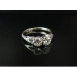 A platinum ring set with two .50ct approx diamonds flanked by tapered diamonds to shoulders.