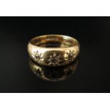 An 18ct gold ring set with three diamonds in rubover star setting. Size P, 6.