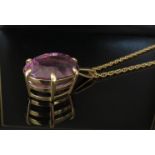 A large oval amethyst pendant in claw mount, 30mm x 24mm, hung on chain, unmarked, 27.