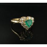 A 9ct gold ring, the central heart shaped emerald framed by 11 round cut diamonds. Size N, 2.