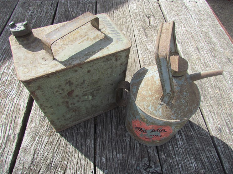 An Aladdin Pink can and a fuel can with brass Esso cap