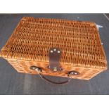 A wicker two person picnic hamper with contents