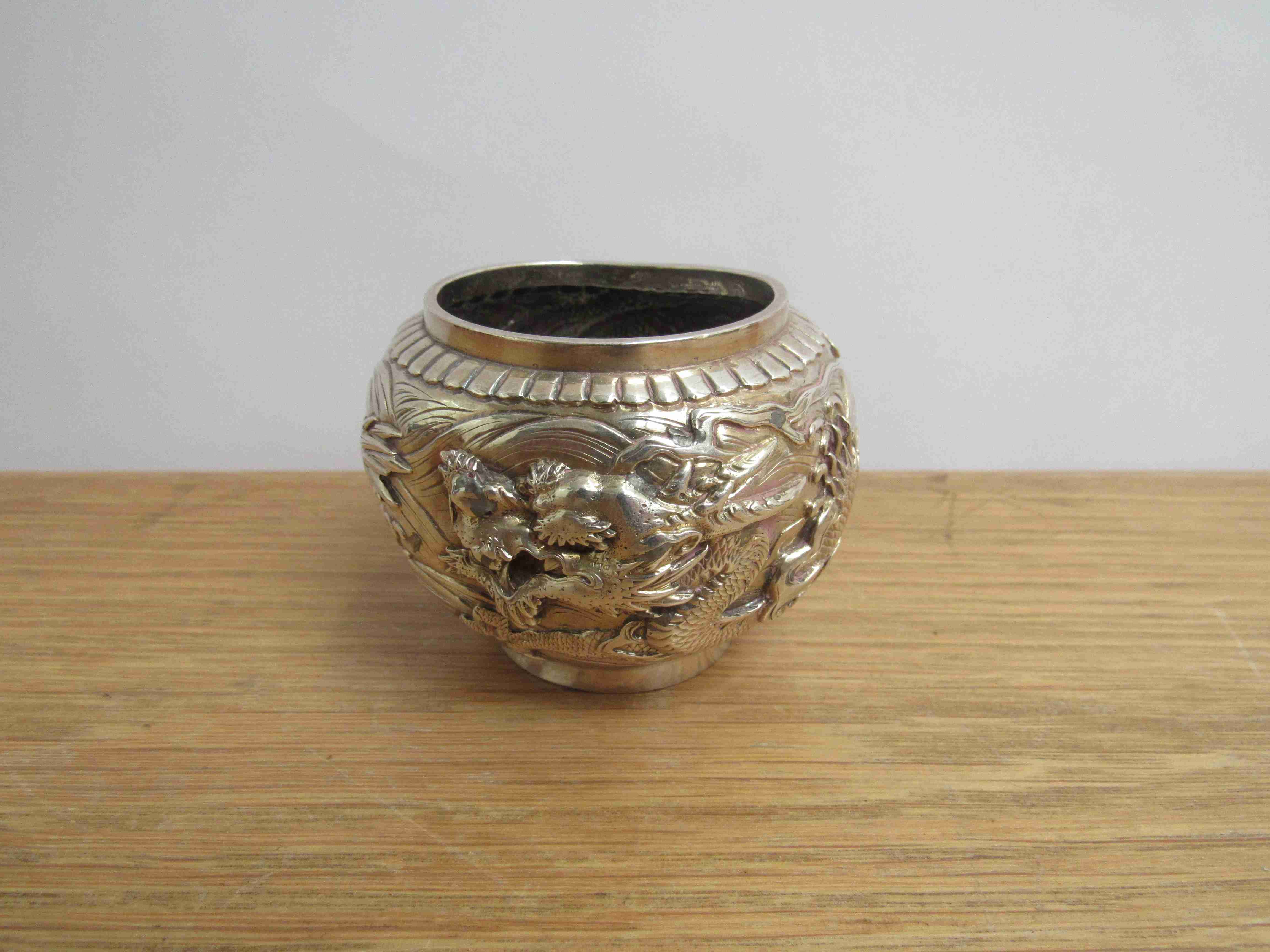 A Chinese silver pot with dragon detail, marks to base, 6cm tall, 8cm diameter,