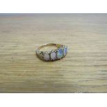 A 9ct gold ring set with five oval graduated opals (middle cracked) size R, 3.