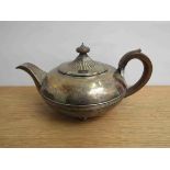 A Georgian silver teapot with treen finial and handle marks rubbed, dented,