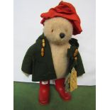 A Gabrielle Designs Paddington Bear in red hat, green duffle coat and red Wellingtons,