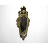 An 18th Century gilt bedroom mirror with scallop and scroll detail, later mirror plate, 61cm x 24cm.