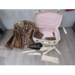 A lady's suitcase and contents including parasol, fans, dressing table items and gloves.