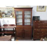 A Victorian mahogany glazed bookcase on two drawer, two cupboard door base, 220cm x 122cm x 48cm.