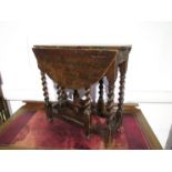 A 17th Century elm topped drop-leaf occasional table with barley twist legs, crack to leg,