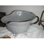 An unusual enamel chamber pot in the shape of a German helmet.