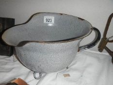 An unusual enamel chamber pot in the shape of a German helmet.