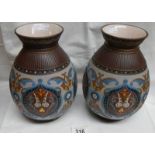 A pair of Mettlach 1829 bulbous vases in bright colours on a mainly light ground with intricate