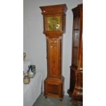 An oak 8 day longcase clock with brass square face