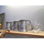 3 armorial metal tankards and a glass example.