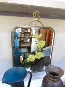 A brass fire screen with painted mirror inset.