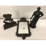 A metal figure of a blacksmith, a horse door stop and a metal framed mirror.