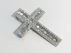 An 18ct gold baguette and brilliant cut diamond cross pendant.