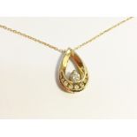 A 14 carat gold and diamond pendant on gold chain.