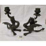 A pair of antique bronze dragon candlesticks.