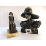 A bronze bust of a lady wearing a hat and a bronze seated Pharoah.