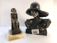 A bronze bust of a lady wearing a hat and a bronze seated Pharoah.