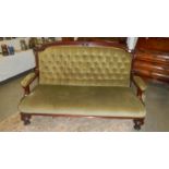 A Georgian mahogany framed armchair sofa with green deep buttoned fabric