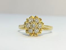 An 18ct yellow gold raised daisy pattern diamond ring, size K.
