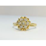 An 18ct yellow gold raised daisy pattern diamond ring, size K.