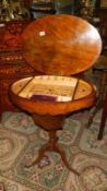 A Victorian sewing table with fretwork interior