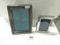 2 hall marked sterling silver photo frames measuring 7" x 5" and 4.5" x 3.5" approximately.