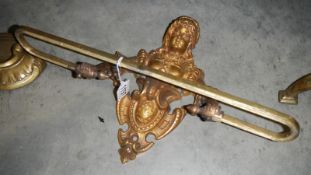 An ornate brass towel rail in the form of a French Victorian lady.