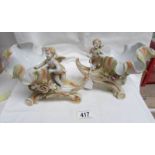 A pair of continental bisque porcelain conch shells surmounted with cherubs.