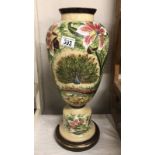 An opaline/opaque glass vase on stand depicting a peacock and flowers. Approximate height 47.