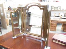 An antique triple mirror in gilded wooden frame.