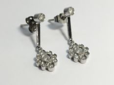 A pair of 18ct white gold drop earrings set with diamonds in a floral design.