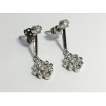 A pair of 18ct white gold drop earrings set with diamonds in a floral design.