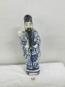 A 19th century Chinese figure, signed on base, approximately 32 cm tall.
