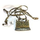 An antique metal and brass purse on leather straps.