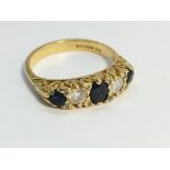 A 1980's 3 stone sapphire and diamond ring in 18ct yellow gold, size P.