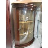 A mahogany corner cupboard with domed glass door.