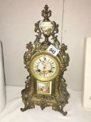 A French ormolu mantel clock with enamel dial and porcelain inset.