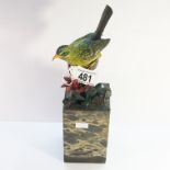A cold painted bronze bird on marble plinth.