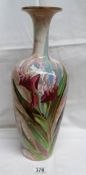A large Doulton Burslem vase with lustrous pinkish white ground painted with red irises and leaves.