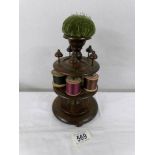 A Victorian wooden cotton reel stand with pin cushion.