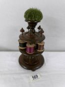 A Victorian wooden cotton reel stand with pin cushion.