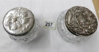 2 silver topped dressing table jars.